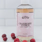 Suntree Soaps bubble bath in a clear bottle with vibrant bubbles, surrounded by soft towels and candles.