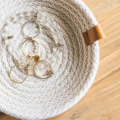 Small woven basket by Woven Handmade, featuring intricate patterns and a natural finish, ideal for organizing jewelry.